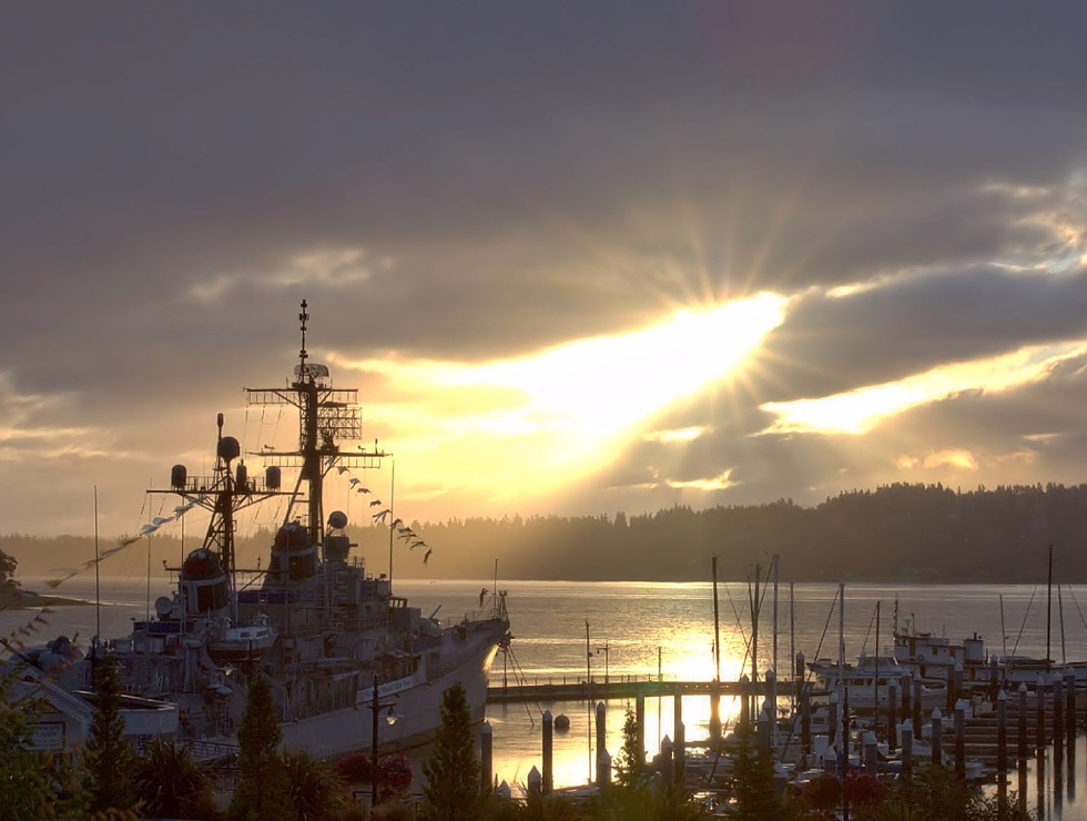 A boat is docked in the water at sunset.